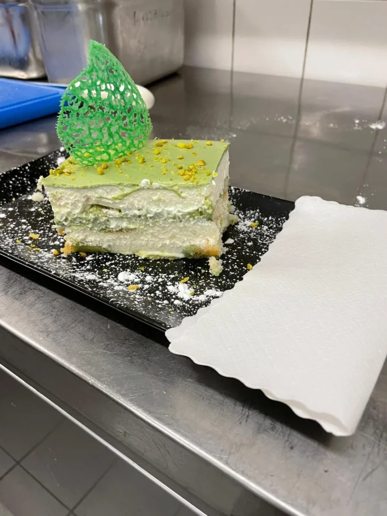 Pistazien-Dessert als Schnitte mit Dekor und Puderzucker – The Dom Konstanz