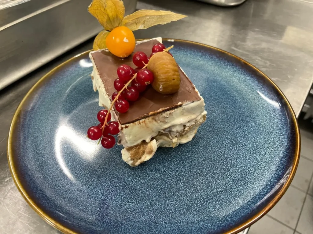 Tiramisu Stück mit Beeren und Physalis auf Teller – The Dom Konstanz