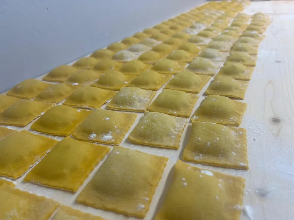 Reihe handgemachter Ravioli auf einem bemehlten Holztisch – The Dom Konstanz