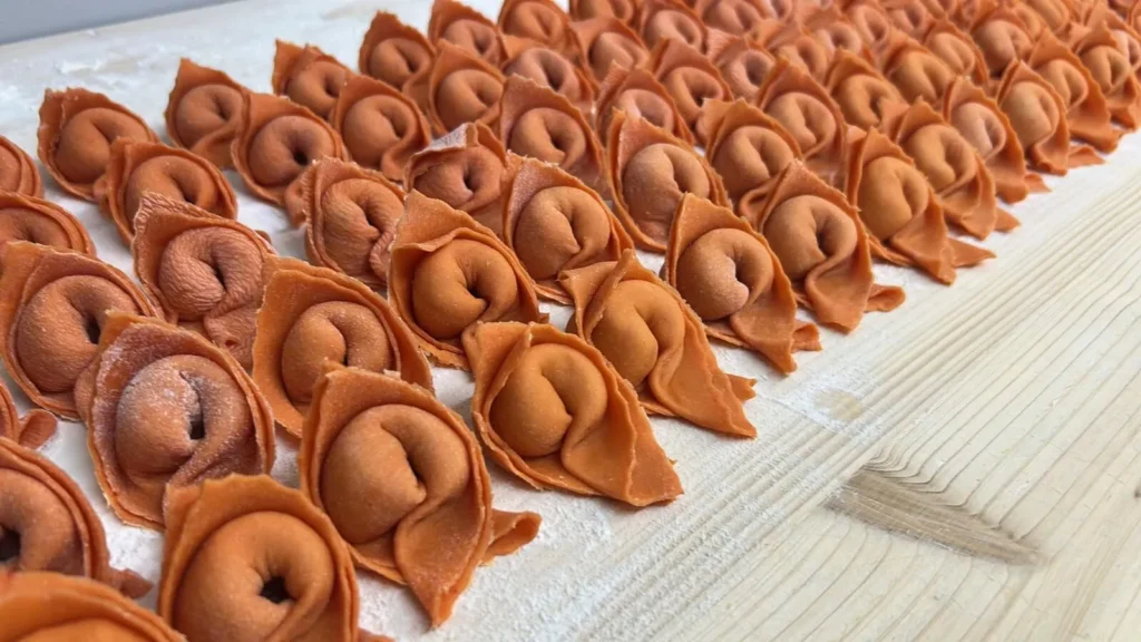 Reihe handgemachter Tortellini auf bemehltem Holztisch – The Dom Konstanz