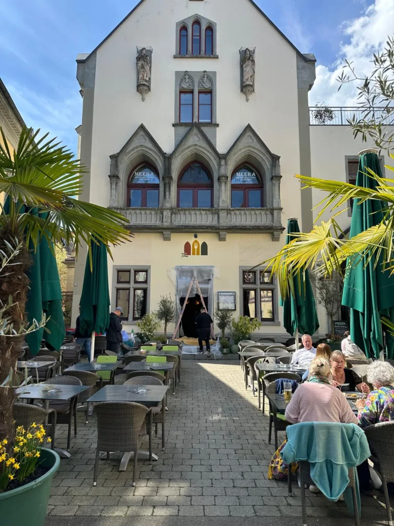 Gäste genießen den sonnigen Frühlingsnachmittag auf der Terrasse des The Dom Restaurant in der Konstanzer Altstadt
