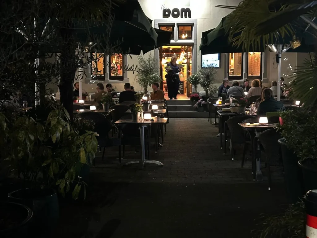 Gaeste auf der Aussenterrasse von The Dom Konstanz bei Nacht mit Kerzenbeleuchtung und mediterranem Flair