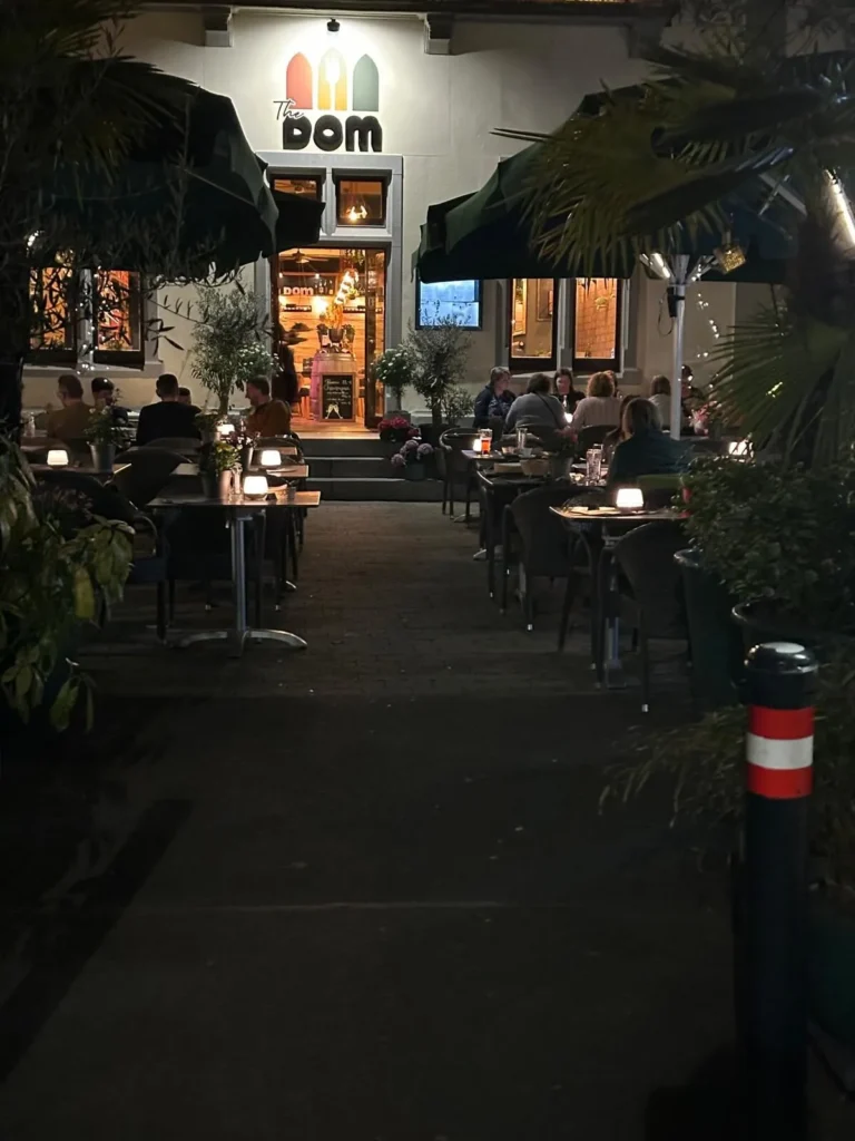 Beleuchteter Eingang von The Dom Konstanz mit stimmungsvoller Aussenterrasse am Abend