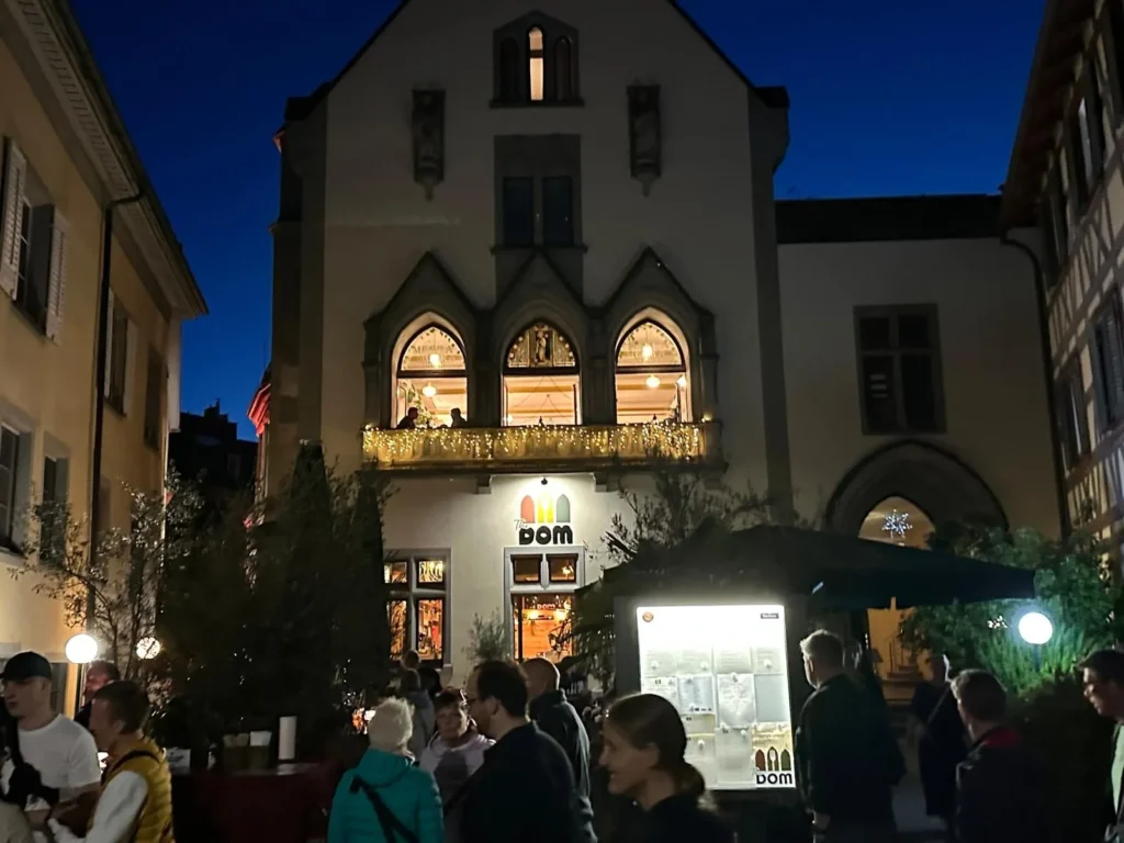 The Dom Konstanz Fassade bei Nacht mit leuchtendem Logo, gotischen Bogenfenstern und Lichterketten