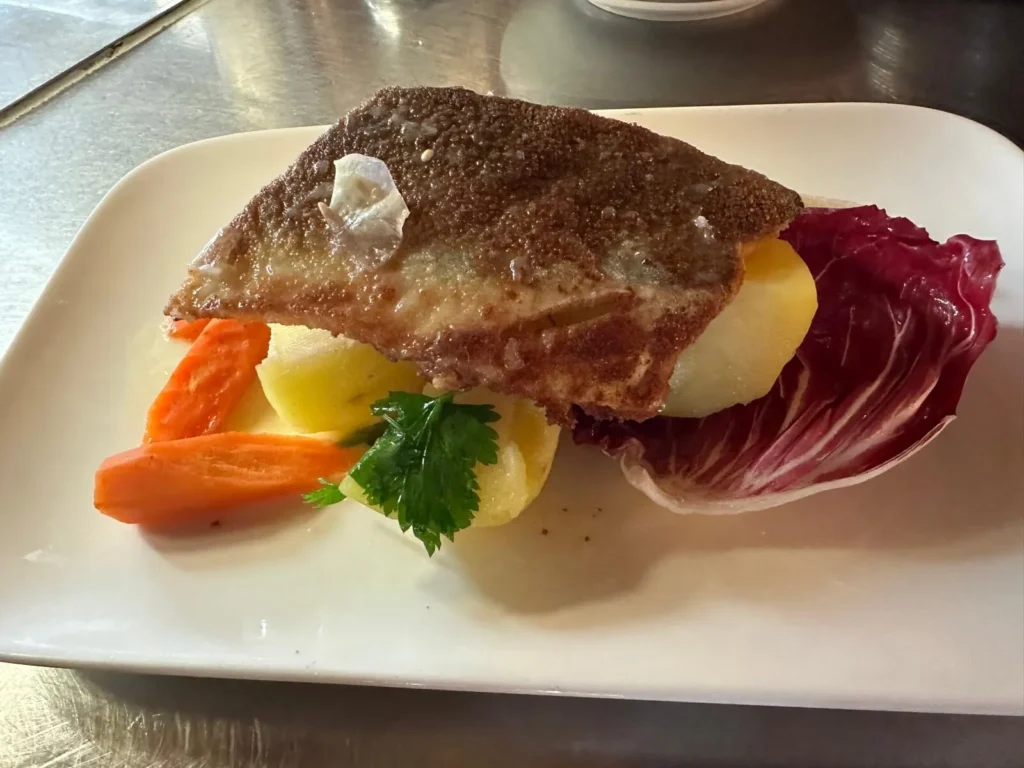 Knusprig gebratenes Fischfilet auf Kartoffeln mit Karotten und Radicchio bei The Dom Konstanz
