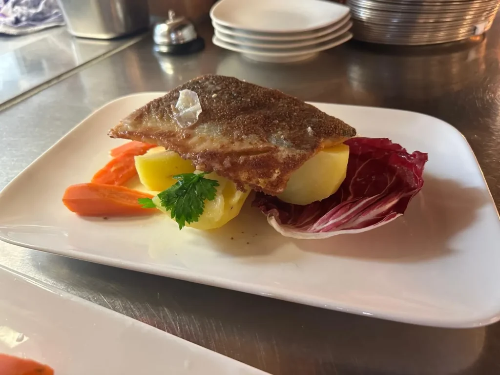 Kross gebratenes Fischfilet auf Kartoffeln mit Radicchio und Karotten in der Kueche von The Dom Konstanz
