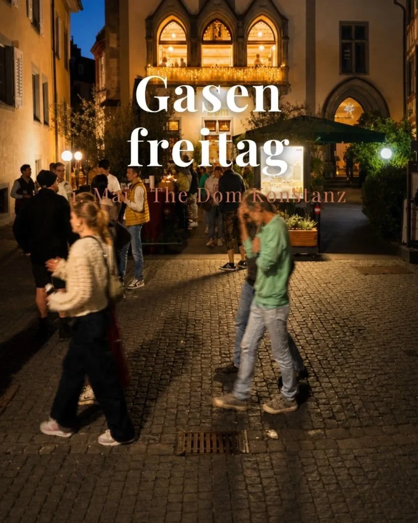 Passanten beim Gasenfreitag am 1. Mai vor der beleuchteten Fassade von The Dom Konstanz