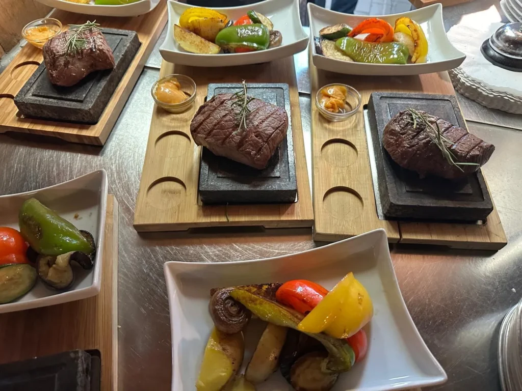 Steaks auf Lavastein mit buntem Grillgemuese servierbereit in der Kueche von The Dom Konstanz