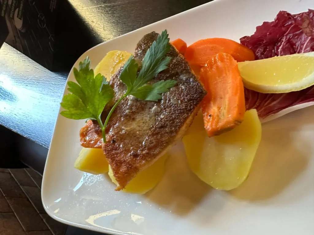 Kross gebratener Lachs mit Karottenscheiben und Radicchio serviert im The Dom Konstanz