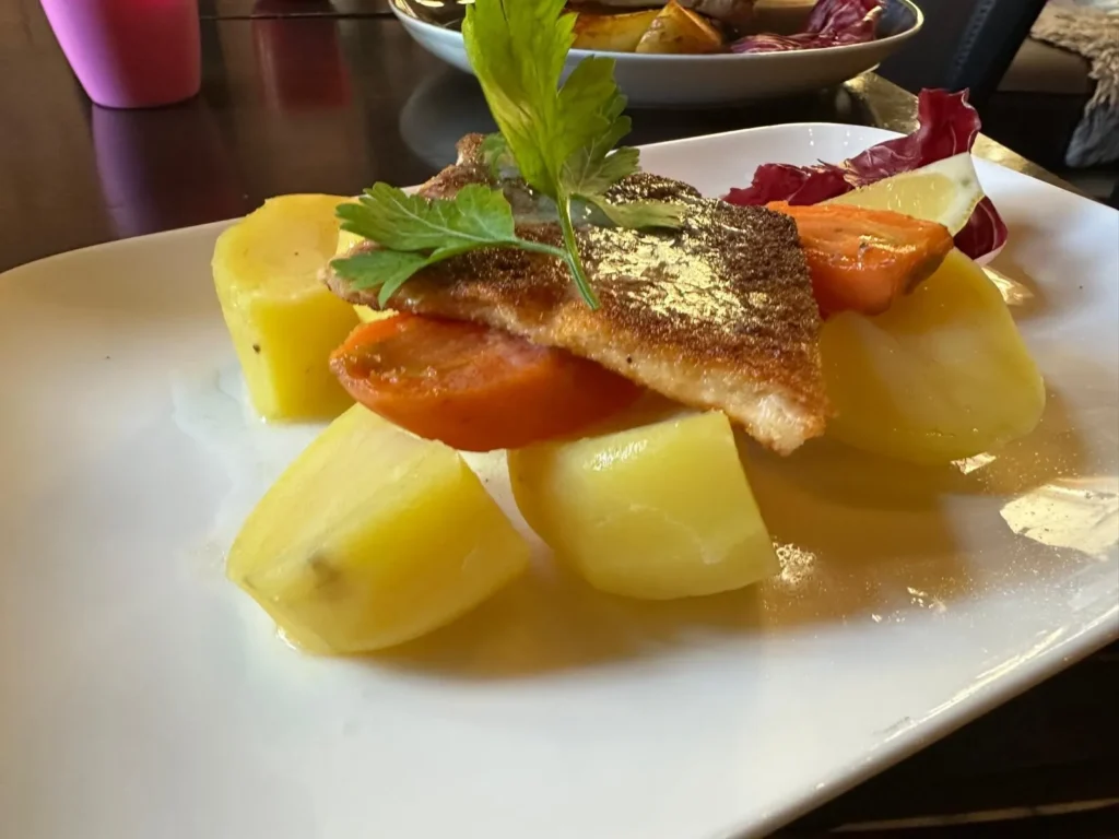 Knusprig gebratenes Lachsfilet auf Salzkartoffeln mit Radicchio und Zitrone im The Dom