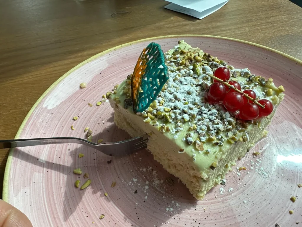 Cremiges Pistazien-Tiramisu mit roten Johannisbeeren und Puderzucker im The Dom