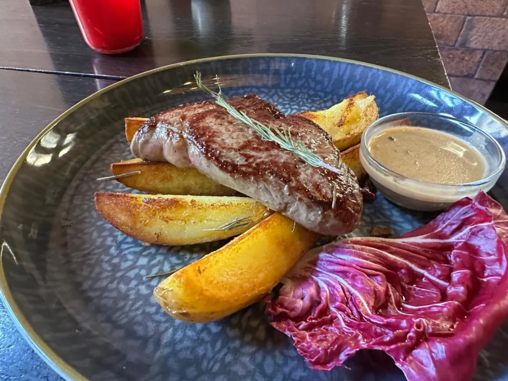 Gegrilltes Rindersteak mit Rosmarin auf knusprigen Kartoffelecken und Radicchio im The Dom