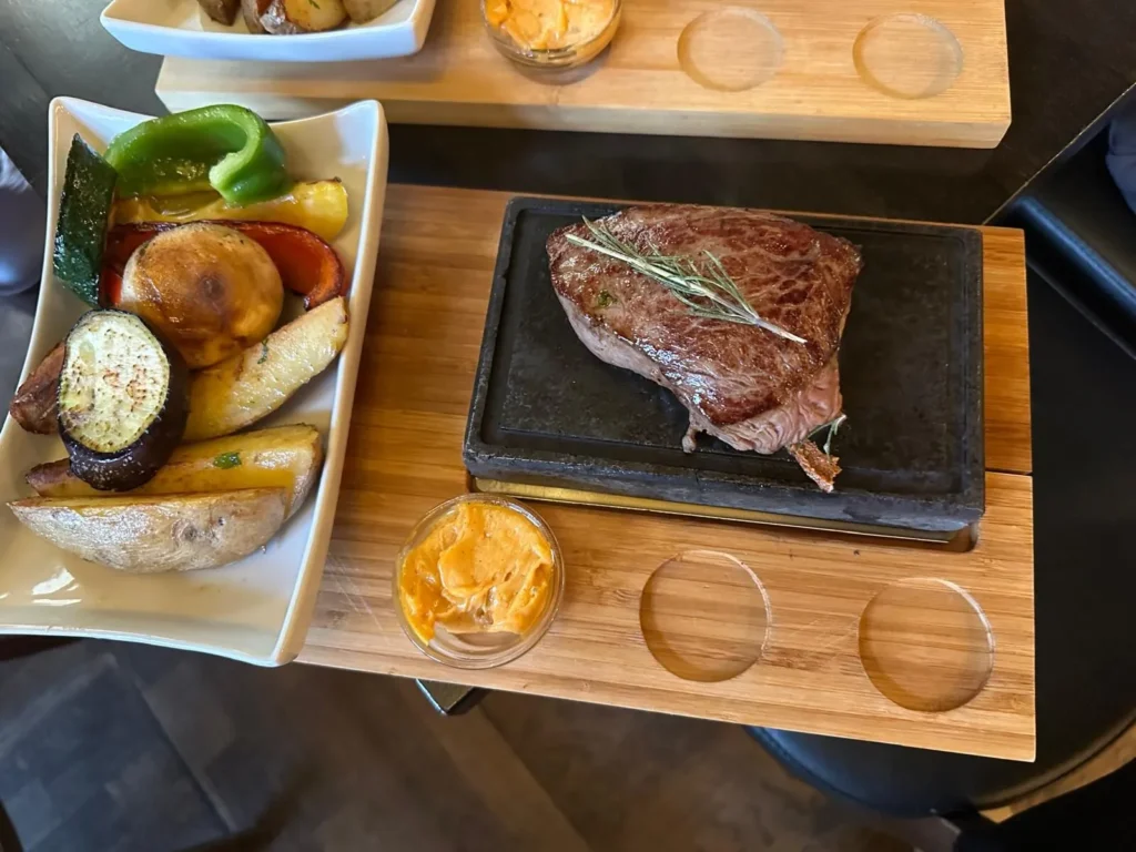 Steak mit Rosmarin auf Steinplatte serviert mit Grillgemuese und Kraeuterbutter bei The Dom Konstanz