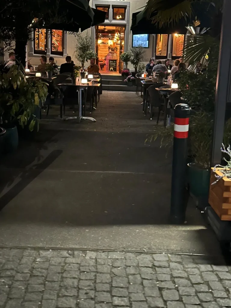Gaeste auf der stimmungsvoll beleuchteten Terrasse von The Dom Konstanz am Abend