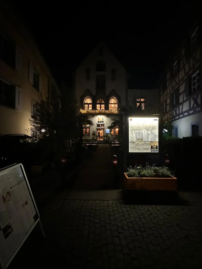 Naechtlicher Blick auf The Dom Konstanz zwischen Fachwerkhaeusern mit gotischen Bogenfenstern und Lichterketten